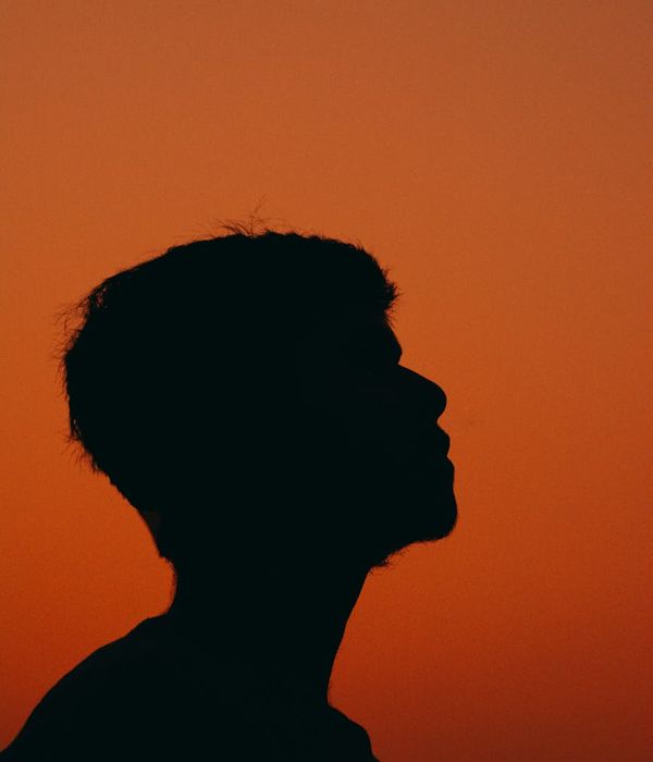 Silhouette of a person meditating against a calm, dark background.